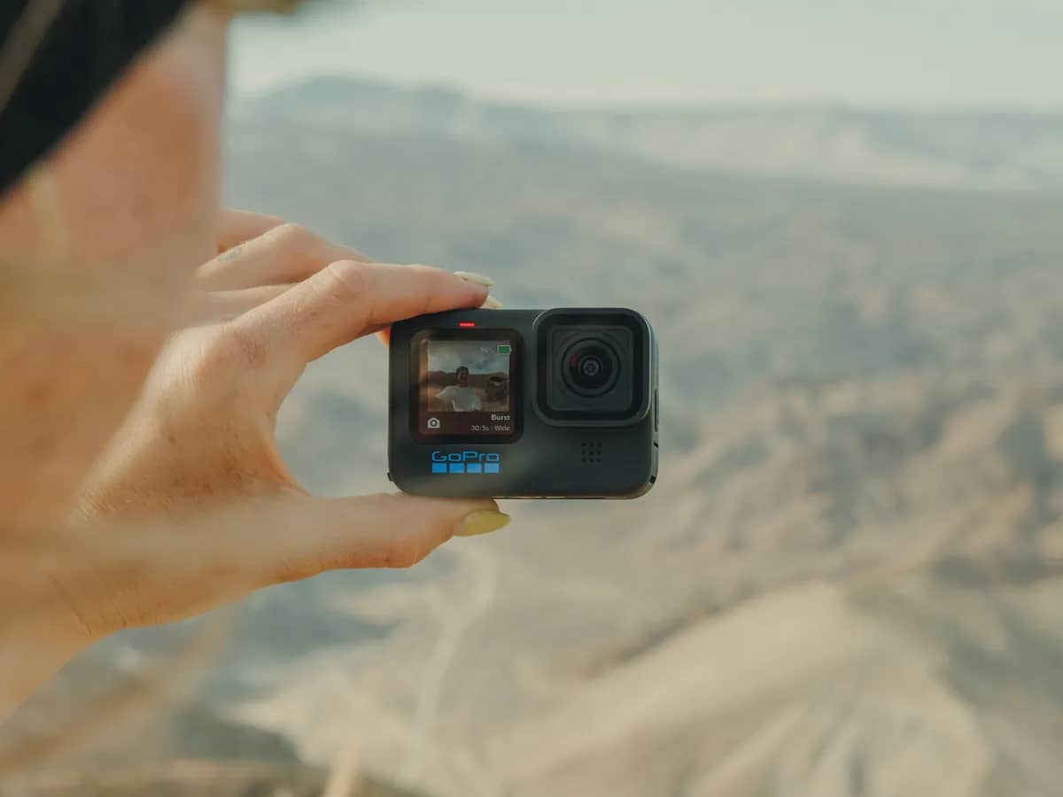 GoPro Hero 11 Black tenue du bout des doigts face à un paysage de désert