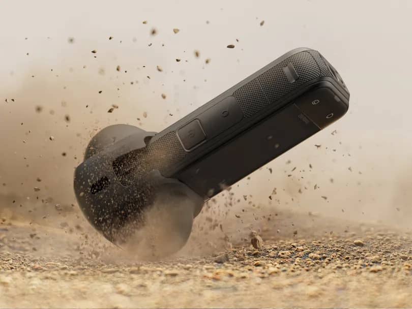 Insta360 X5 qui rebondit dans le sable et la poussière, boîtier robuste en avant