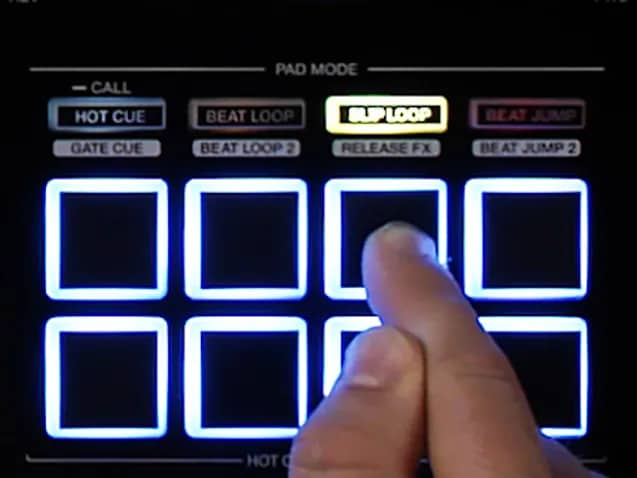 Un doigt presse l’un des huit pads lumineux du Pioneer XDJ-RX3