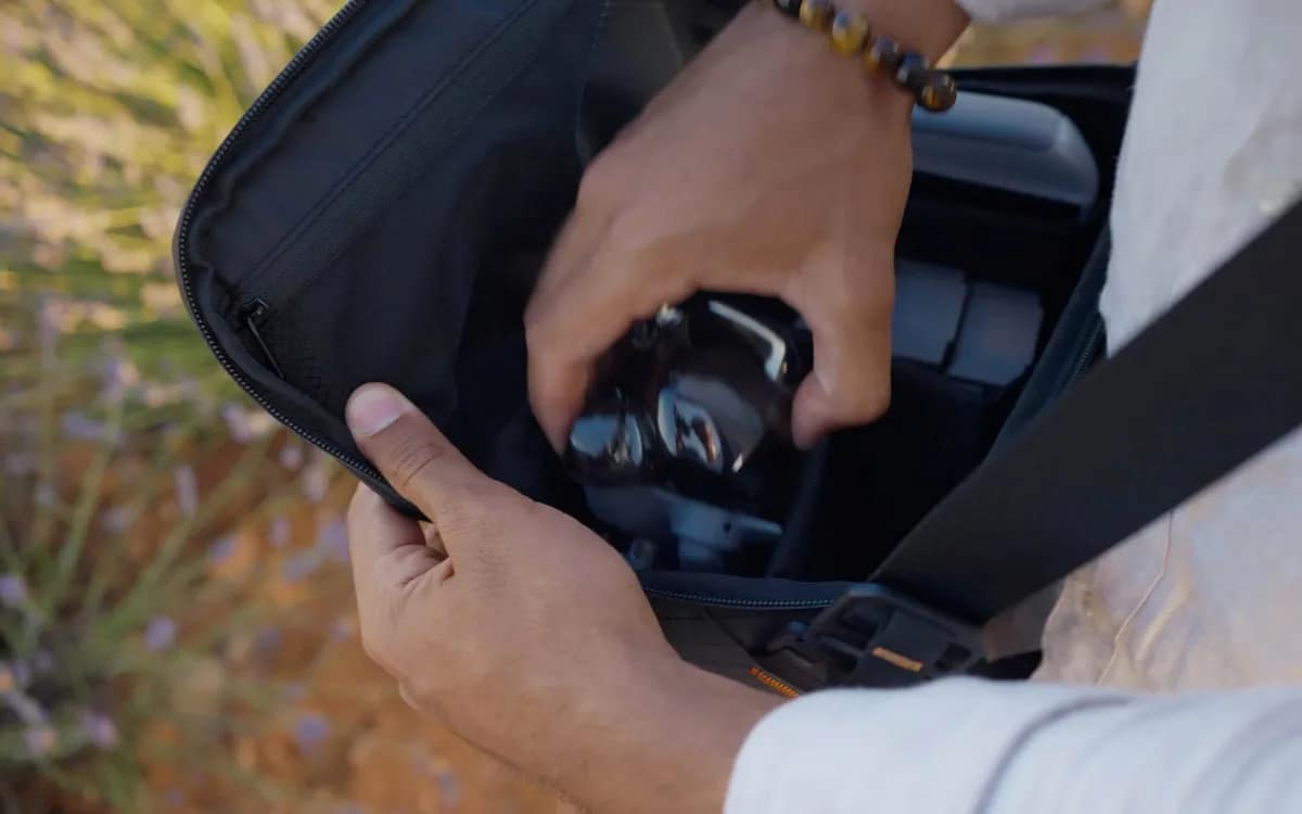 Un pilota tira fuori il suo drone DJI Mini 5 Pro dalla borsa prima del volo