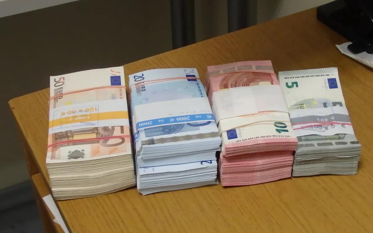 Liasses de billets en euros posées sur un bureau