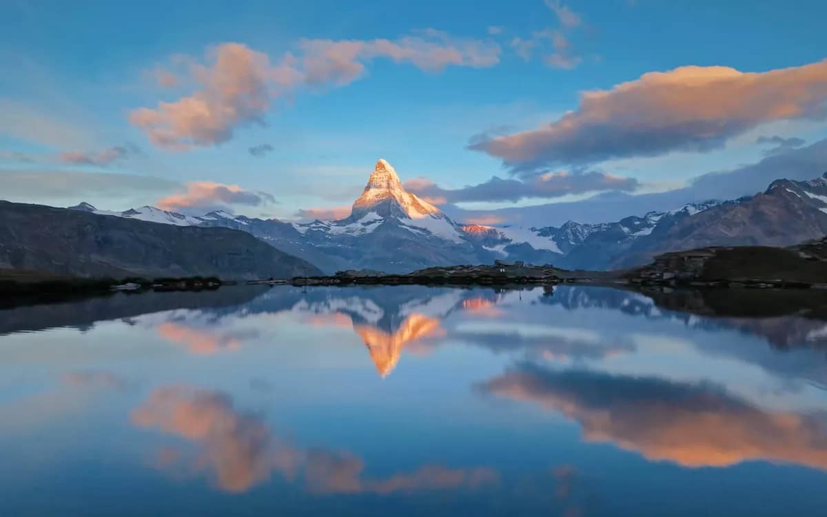 Veduta aerea di una vetta alpina riflessa in un lago di montagna all'alba