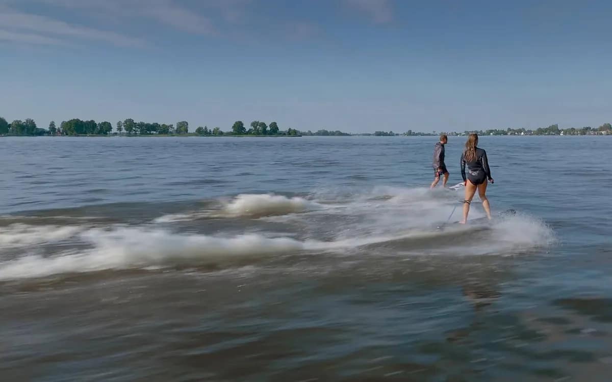 Veduta aerea di due persone che fanno wakesurf su un lago, filmata da un drone DJI