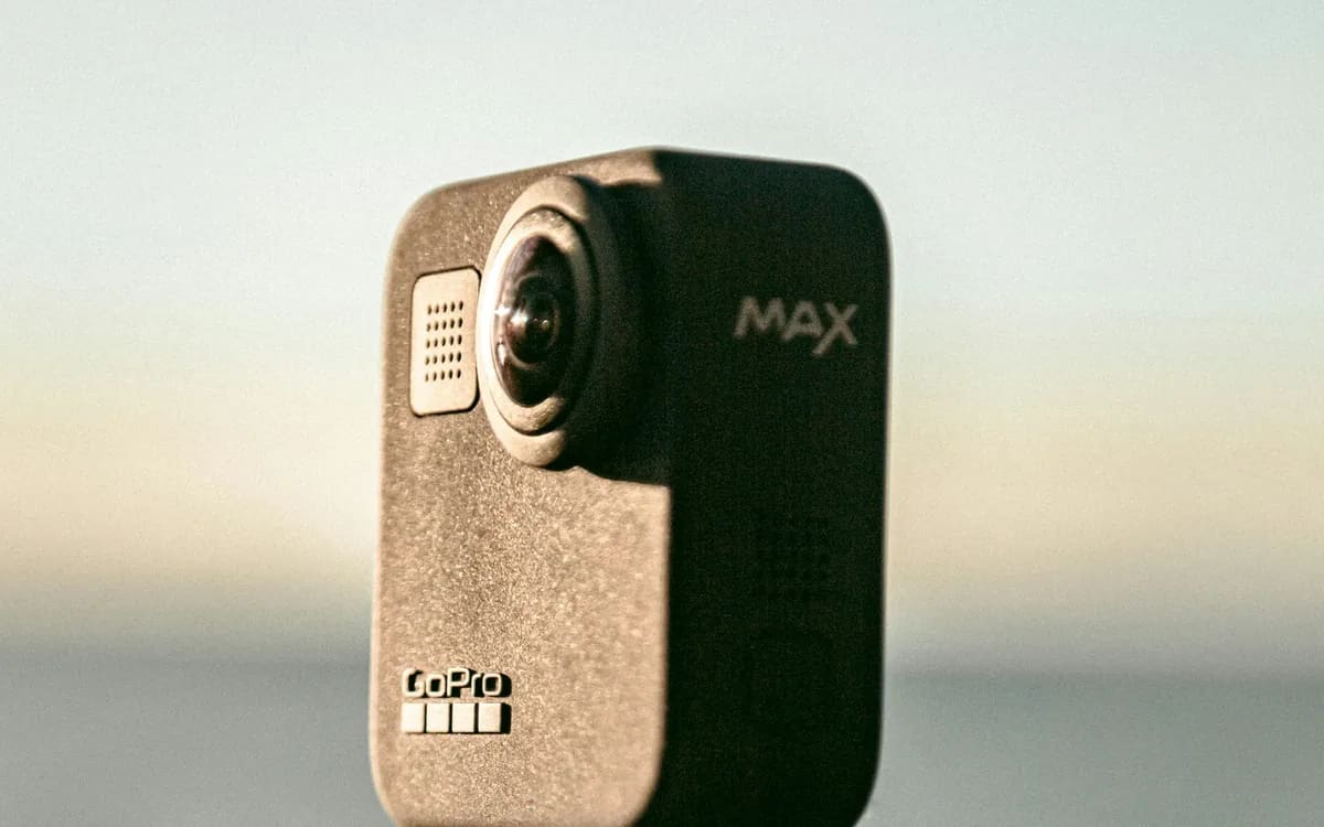 Twee camera's Insta360 X5 vanaf de voorkant gezien, bolvormige lenzen uitsteken, onder opspattend water