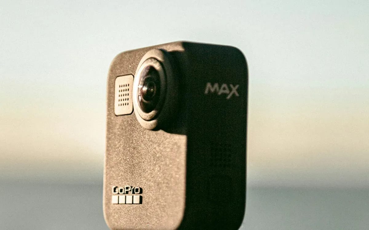 Caméra 360 noire posée sur une surface claire, ses deux objectifs sphériques bien visibles