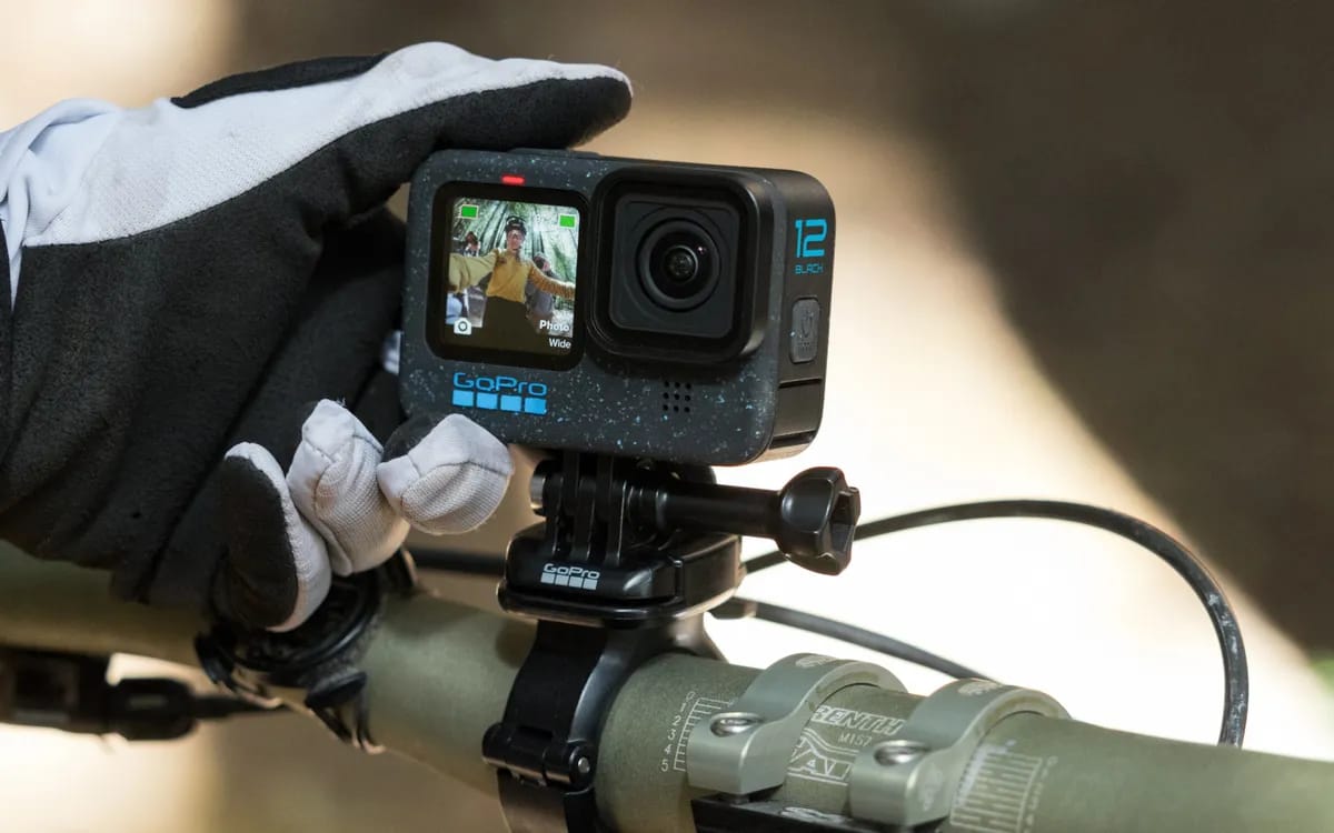 GoPro HERO 12 Black fixée sur un guidon de VTT, réglée par une main gantée