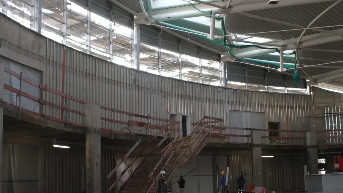 Intérieur d’un bâtiment en construction : charpente métallique et échafaudages