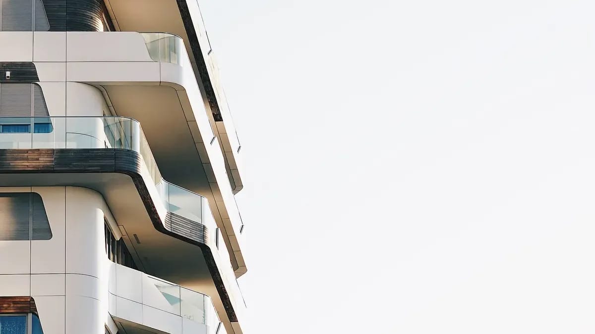 Angle d’un immeuble contemporain aux balcons arrondis, sur ciel clair