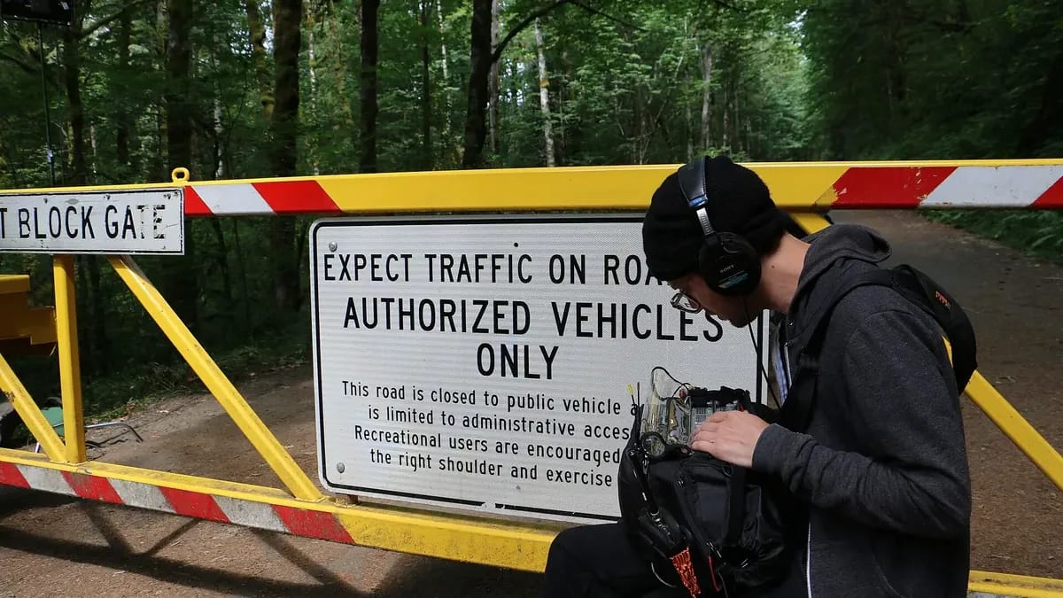 Un ingénieur du son au casque règle son enregistreur en extérieur