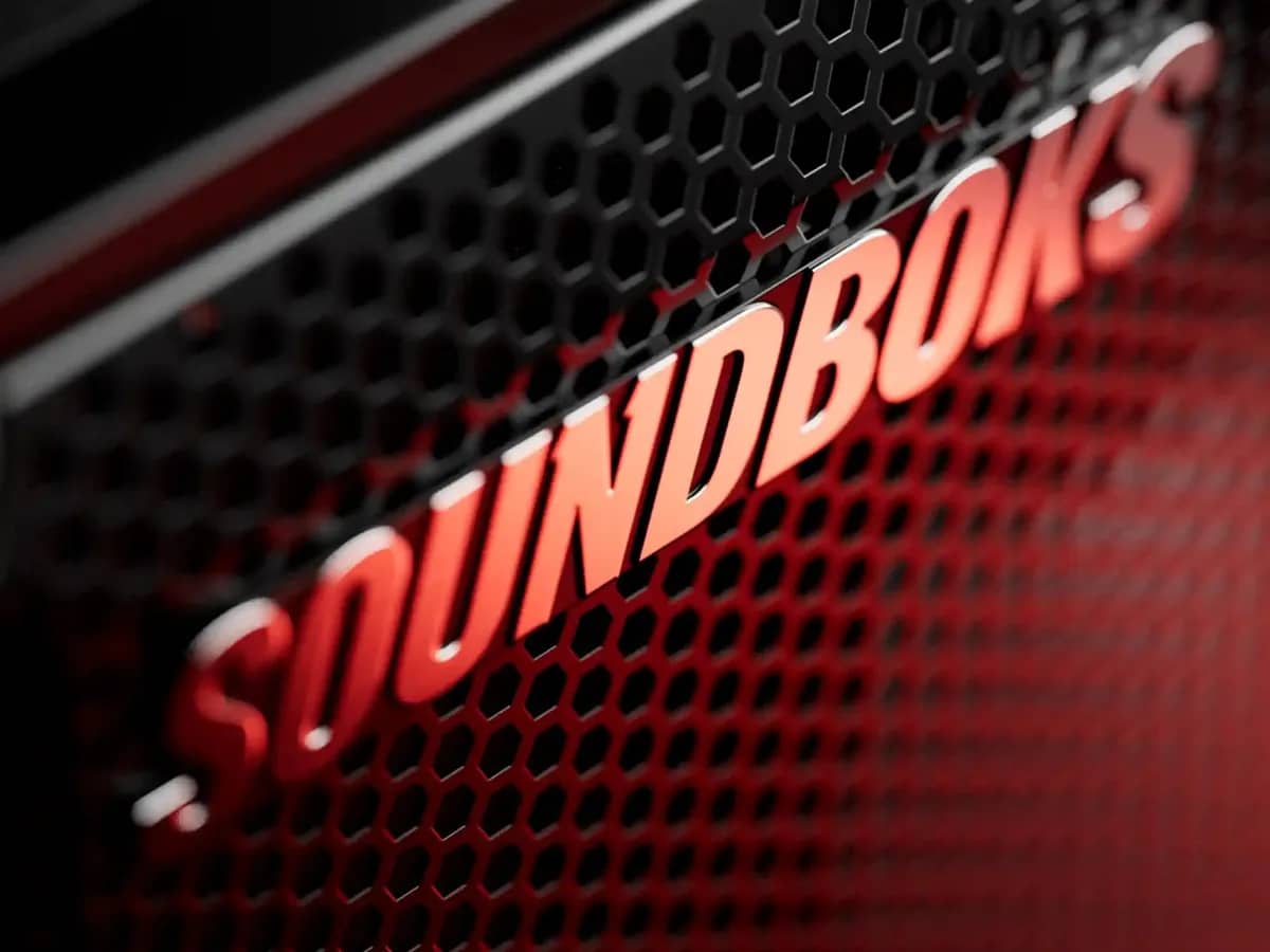 Grille de la Soundboks 4 et son logo sous un éclairage rouge