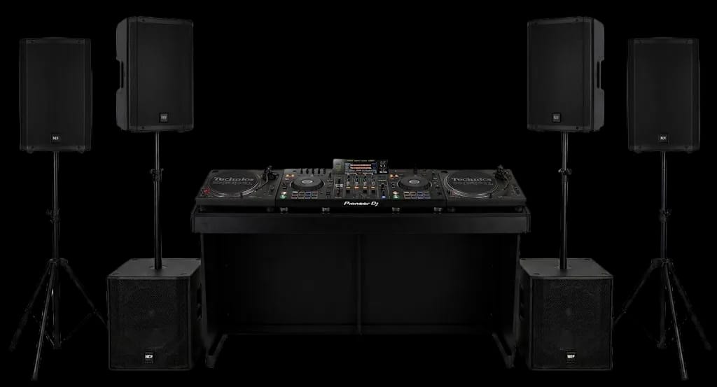 DJ booth noir avec deux platines Technics et un Pioneer XDJ-RX3, quatre enceintes RCF ART 912-A et deux caissons RCF SUB 15-AX