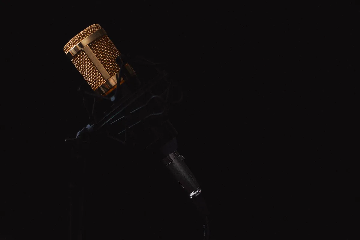 Micro de studio suspendu dans sa suspension élastique, sur fond noir
