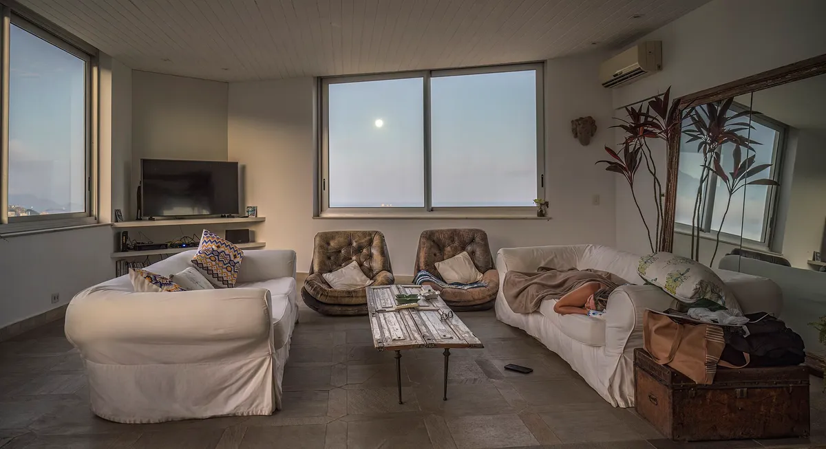 Séjour d’appartement en angle, deux baies vitrées et un canapé blanc en L