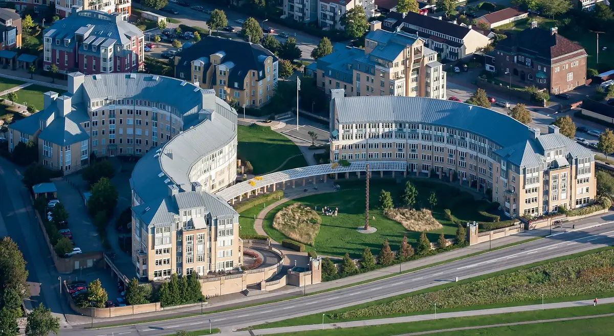 Woningcomplex met lichte gevels vanuit de lucht, gazon en scherpe schaduwen van de gebouwen