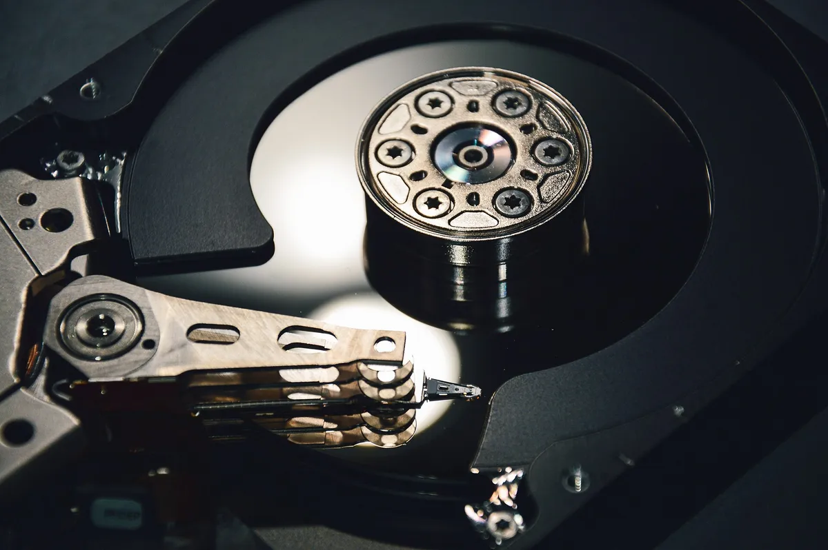 Intérieur d’un disque dur ouvert, plateau miroir et bras de lecture