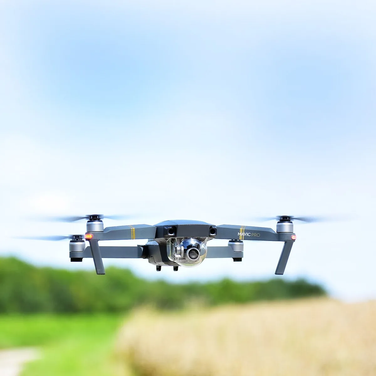 Drone grigio DJI in bilico a bassa quota su un campo verde
