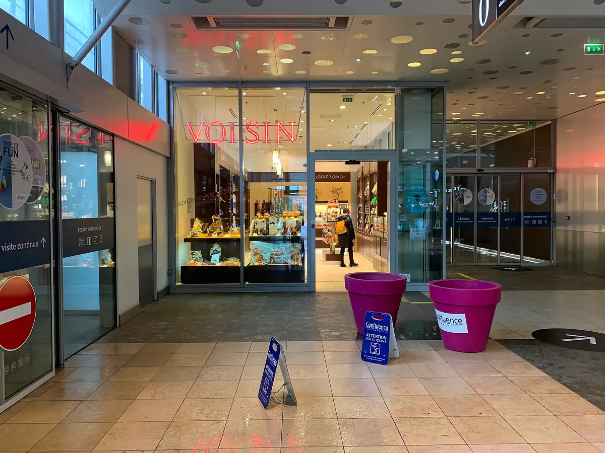 The glazed entrance of a shop inside a shopping arcade, lit display windows